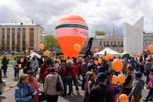 Участники акции готовятся к флешбому по запуску воздушных шаров на фоне большой инсталяции символизирующей "Планету Семьи"